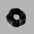 Vue détaillée d'un chouchou en peluche noire douce avec une texture en fausse fourrure - Noir