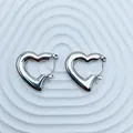 Detailed macro view of polished silver heart-shaped stainless steel hoop earrings - 18K Gold / Silver Classic Glossy Heart (096)