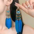 Detailed close-up of long bohemian blue feather earrings with intricate gold beads - Ear Hook - Blue Petal