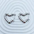 Close-up of silver-tone stainless steel heart hoop earrings with wavy texture. - 18K Gold / Silver Wave Texture Heart (092)