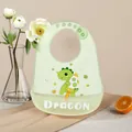 Cute green waterproof silicone baby bib with cartoon dragon print and food catcher - Rocket Dinosaur