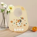 Adjustable beige silicone baby bib featuring a cute space bear astronaut for feeding - Yellow Space Bear
