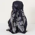 Detailed view of a navy blue paisley print satin headscarf tied on a mannequin head - 90*90cm / Paisley Navy