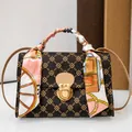 Elegant brown monogram crossbody bag featuring a floral silk scarf wrapped handle detail - Coffee
