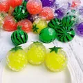 Vue détaillée de balles anti-stress en forme de fruits avec perles d'eau colorées - Squishy à Perles / Ananas