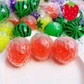 Détail en gros plan d'un jouet antistress fraise avec des perles d'eau rouges - Squishy à Perles / Fraise