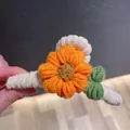 Close-up of handmade orange crochet flower hair claw clip showing yarn texture details. - Orange