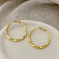 Detailed close-up view of elegant gold plated twisted hoop earrings on ceramic plate - Twisted Texture Hoop (YG4810) / 4cm Size / Gold