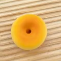 Realistic yellow donut shaped slow-rebound squishy toy placed on a light wooden board - Random Donut