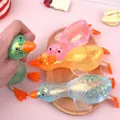 Detailansicht farbenfroher Glitzer-Enten-Squishys auf einem dekorativen Holztablett. - Malzzucker Stretch Ente