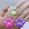 Close-up of three colorful translucent cat paw squishy toys with star confetti - Transparent Multicolor (Mixed)