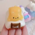 Simpatico orsetto giallo squishy su base bianca con dettaglio tavoletta di cioccolato Sweet - Cane Morbido