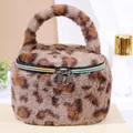 Portable cylindrical plush cosmetic bag featuring leopard print and a top handle for travel - Camel