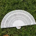 Elegant white hollow folding fan with intricate patterns, perfect for weddings and events - White