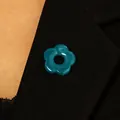 Detail view of a teal hollow flower brooch on a black blazer acting as a glasses holder - 04 Blue-green K-823