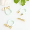 Detail view of mint green enamel and gold-plated copper U-shaped horseshoe buckles. - Mint Green