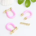 Close-up of pink enamel gold-plated copper U-shaped horseshoe buckle components - Pink