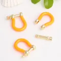 Detail view of orange enamel U-shaped copper horse-hoof buckles for DIY jewelry making - Orange