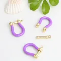 Gros plan sur les fermoirs en forme de fer à cheval en émail violet pour bijoux - Violet