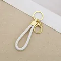 Close-up of white braided leather rope keychain with shiny gold metal ring. - Generation 1 Round Dragon Woven Buckle (Light Gold) / White