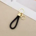 Handmade black braided leather rope keychain with durable gold-tone metal rings. - Generation 1 Round Dragon Woven Buckle (Light Gold) / Black