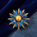 Elegant vintage flower brooch featuring blue crystal petals and a golden pearl center - White Rhinestone & Blue Accessories with Golden Artificial Pearl