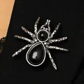 Vintage silver spider brooch pin featuring black gemstones displayed on a black silk tie - Antique Silver Red Gemstone Spider Style