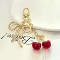 Porte-clés cerise rouge 3D exquis avec pendentif nœud doré pour sac à main - Grand nœud papillon cerise transparente / Rouge + Or