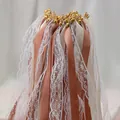 Primer plano de varitas de cinta de boda con encaje, cintas de raso y cascabeles - Varita de Encaje / Marrón