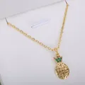 Gold-colored necklace with pineapple pendant and green crystal details - Hollow Gold Pineapple Necklace (xl2)