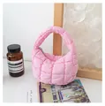 Mini borsa a nuvola rosa trapuntata in un ambiente lifestyle minimalista con decori. - Rosa chiaro