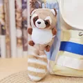 Close-up view of a cute raccoon plush keychain hanging on a stylish cream backpack - Round Bead Chain / Brown