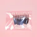 High-quality set of 10 black ink gel pen refills in a clear plastic bag on pink surface - Refill