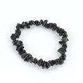 Detailed close-up view of a stretchy bracelet made from polished black natural stone chips - Obsidian