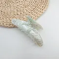 Detailed view of a summer starfish hair claw clip with sparkling rhinestones and marble texture - Mermaid White (White Rhinestone)