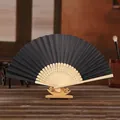Traditional elegant black 6-inch folding fan displayed on a wooden stand for DIY - Black