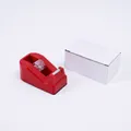 Compact red desktop tape dispenser with a minimalist white cardboard packaging box - Red