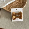 Elegant Korean style caramel ribbed ribbon bow hair clips displayed on a white card - Ribbon Bow Hair Clip Pair (52-B87) / 2 Pcs/Set / Ginger Yellow