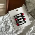Set of 4 black oval snap hair clips with red beads displayed on a white cardboard card - Teardrop Hair Clip (JX-B166) / Set of 4 / Black (with Bright Red Bead)