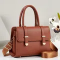 Detailed macro view of a brown textured leather handbag with elegant gold-tone hardware - Earthy Yellow