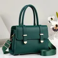Close-up view of the dark green textured leather handbag with gold metal accents - Green