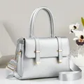 Elegant silver metallic handbag with wide shoulder strap and premium gold hardware - Silver