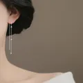 Eleganti orecchini lunghi in argento a nappa con catena a sfere indossati da una modella - Infilatore per Orecchie Con Nappa a Sfera