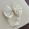 Elegant cream white infant lace headband featuring a large bow with a pearl floral center - Beige Lace Headband with Rhinestones