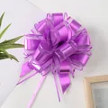 Detaillierte Makroaufnahme einer lila Geschenk-Ziehschleife aus Organza und Metallband. - Helllila
