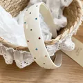 Vista detallada de diadema de acrílico crema con pedrería de colores sobre fondo encaje - Blanco (Strass de Colores)