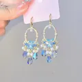 Detailed close-up showing elegant blue butterfly hollow pendant earrings with pearls and crystals - Streaming Flower Tassel (62# Earring Hook-Gold) / Blue