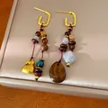 Detailed view of handmade ethnic earrings with wooden beads and resin pendants - Earrings / Gold Brown