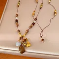 Detailed view of ethnic beaded necklace with golden fortune bag and resin pendant - Necklace / Gold Brown