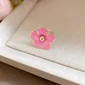 Detalle de un anillo de flor de esmalte rosa con elegante borde dorado en una bandeja - Anillo / Rosa
